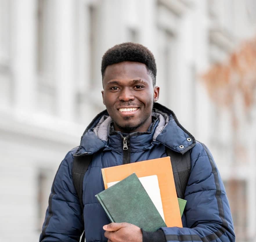 Smiling student holding notebooks
